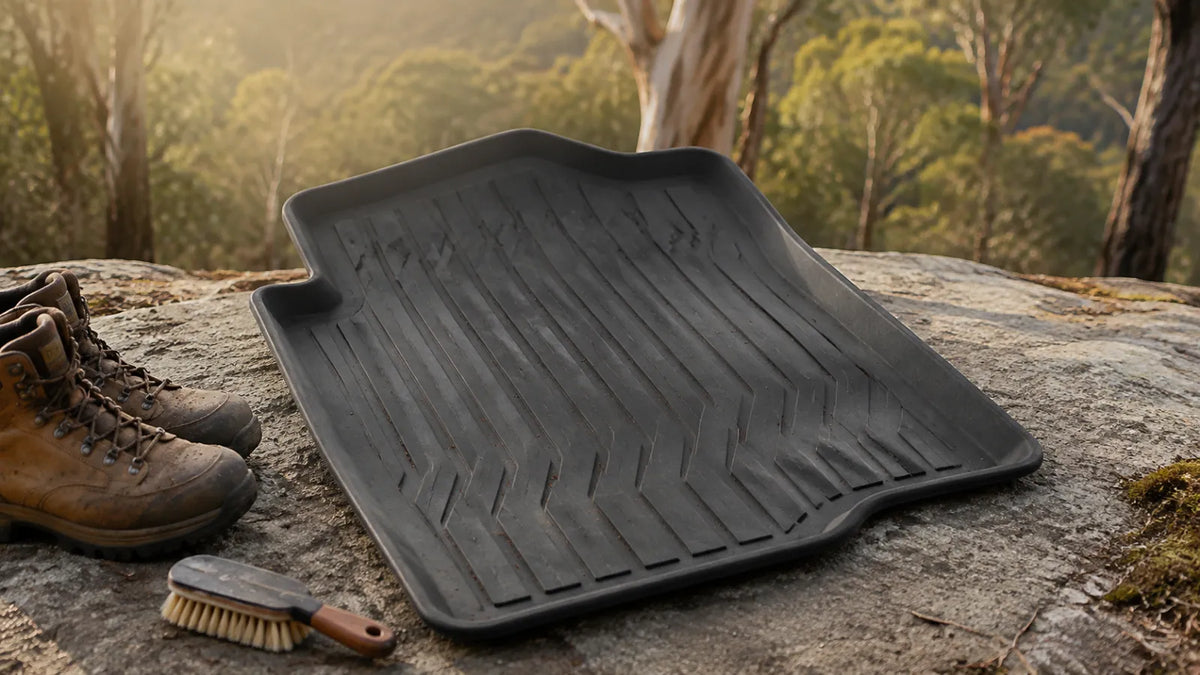 Generic moulded car floor mat with hiking boots and a cleaning brush beside an Australian bush campsite