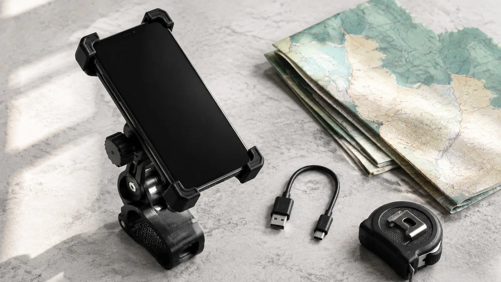 Generic phone holder, blank-screen phone, USB cable and map arranged for trip planning