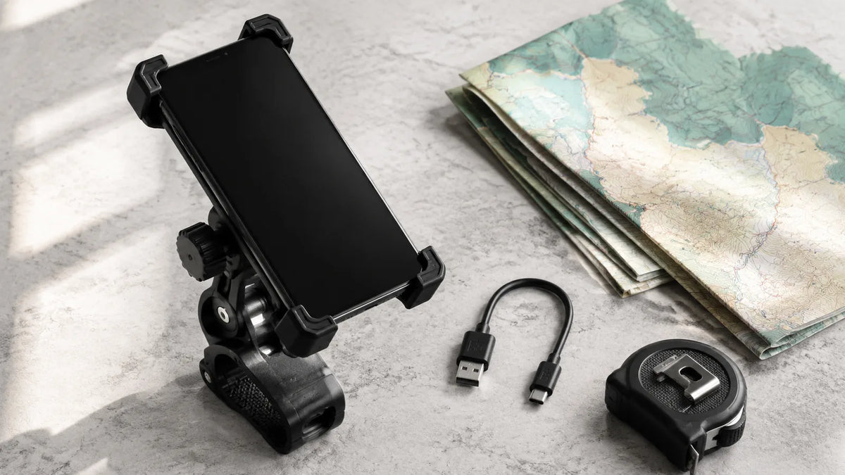 Generic phone holder, blank-screen phone, USB cable and map arranged for trip planning
